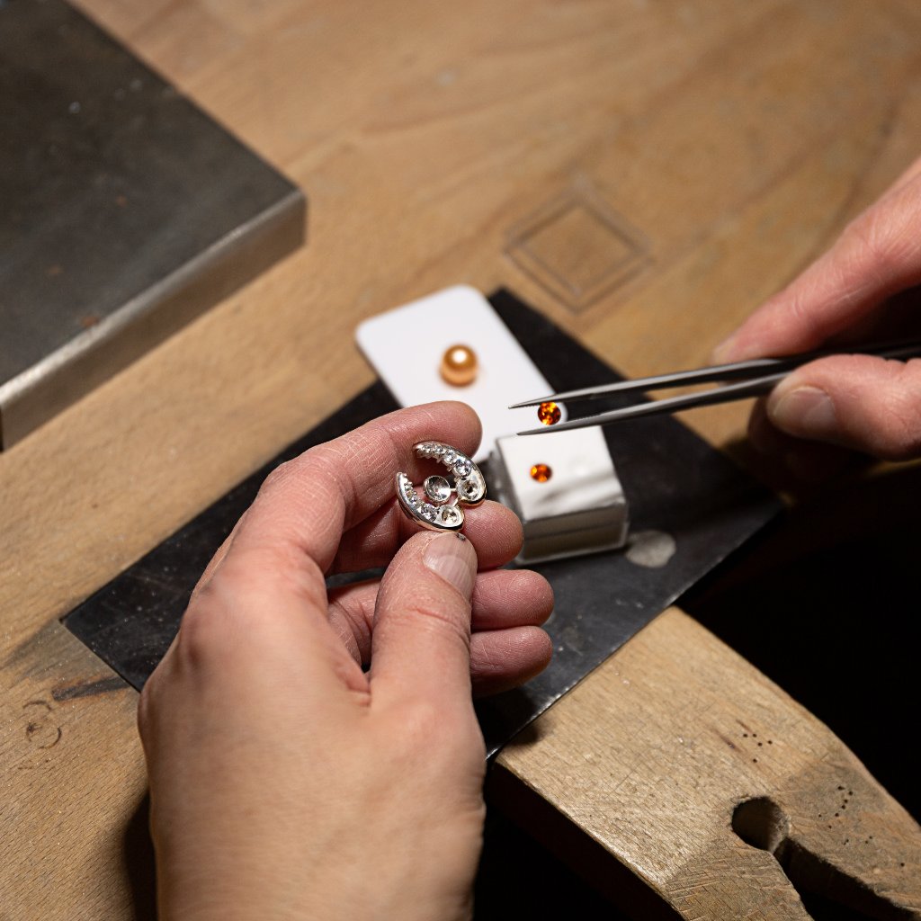 The maker's hands at work in the studio creating a handmade jewel